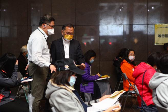 台北市副市长蔡炳坤（站立者右）17日前往市府疫苗注射站视察，关心现场等待施打的民眾、了解接种流程。（张立勋摄）