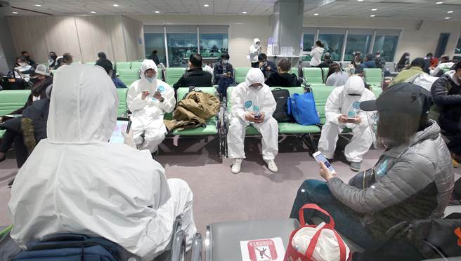 明（18日）起放宽分流条件，20到49岁，落地採检阳性且经现场人员评估无急性身体状况者，均优先收治于加强版防疫旅馆或加强版集检所。图为长程航班入境旅客等待检测结果。（范扬光摄）