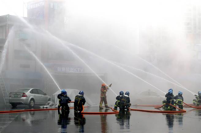 消防局出動雲梯車從空中灑水，搭配地面上的多條消防水線，聯合壓制火勢，避免延燒。（黃世麒攝）
