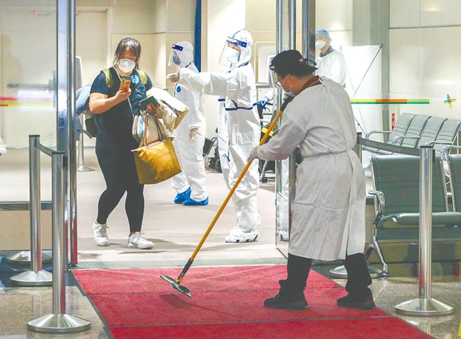 桃园机场依风险不同，要求员工穿着不同防护装备，风险高者着「兔宝宝装」，风险低者则穿防水隔离衣。（陈麒全摄）