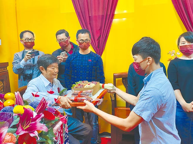 17岁吴致锋（右）向台南市传统工艺「神明银帽」保存者郭春福（左）献上肉脯、芹菜、红豆、莲子、红枣、桂圆等束修六礼。（曹婷婷摄）