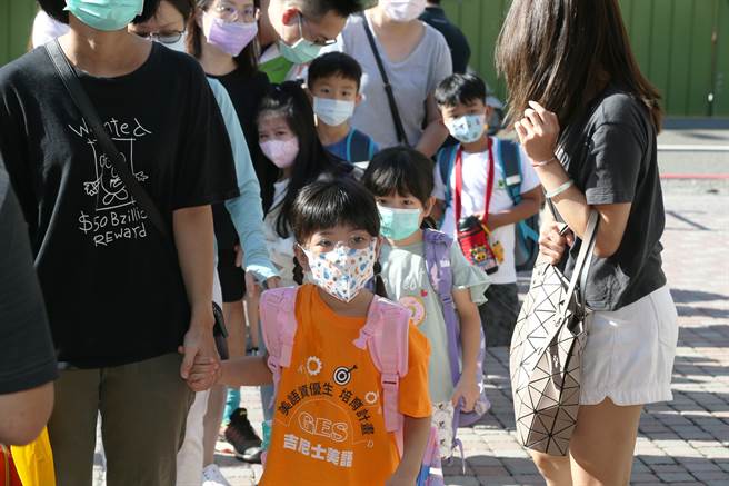 近期国外青少年与幼童染疫快速增加，Omicron疫情入侵台湾校园格外让父母们担忧。图为台湾的家长送学童上学。（图／中新社）
