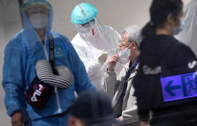 国内首起机场防疫人员案17928基因定序出炉，与桃机群聚个案无关，研判是因为搜集口水唾液时染疫。医护人员为长程航班入境旅客採检。非新闻当事人。（范扬光摄）