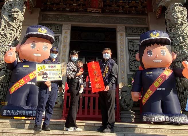 中市警局雾峰分局日前于大里杙福兴宫举办挥毫迎春暨犯罪预防宣导活动，2个大型警察娃娃站在庙门口展现气势，并分送书画家春联。（雾峰分局提供／黄国峰台中传真）