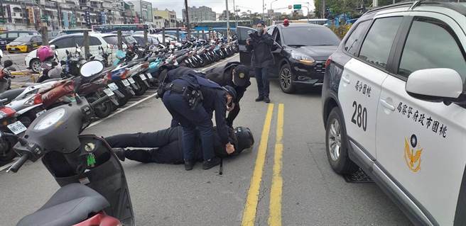 桃警防搶演練也要落實防疫，「搶匪」一度體溫太高遭拒於門外。(警方提供／蔡依珍桃園傳真)