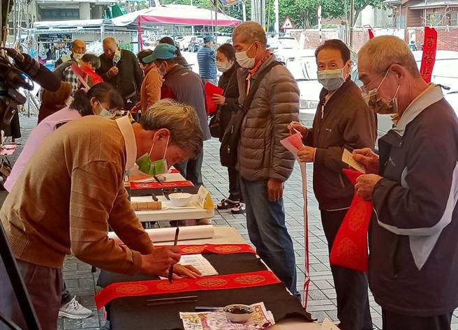 台中市議長張清照邀請10位書法老師揮毫寫春聯，吸引許多鄉親排隊索取。（議長張清照服務處提供）