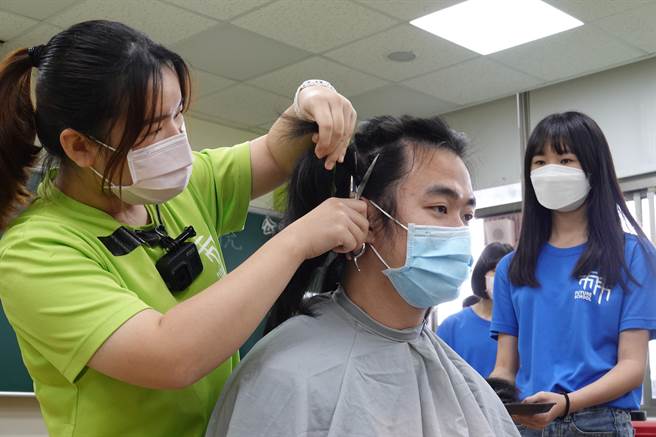 有感癌友化療受落髮之苦，台東育仁高中學生響應捐髮活動，活動由導師張家維（中）率先剪去長髮。（蔡旻妤攝）