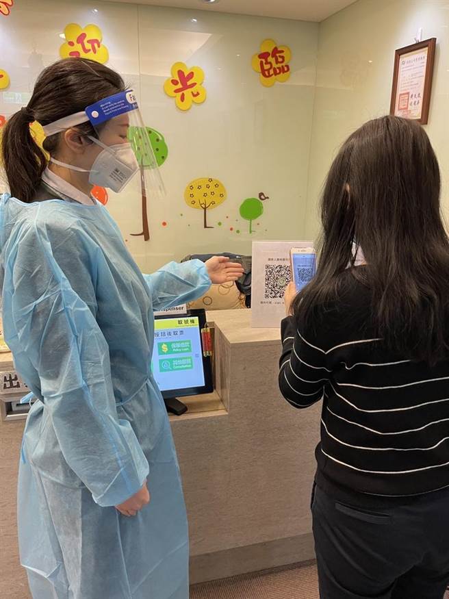 （國泰人壽據點桃園引導員穿防護衣、戴面罩防疫。圖／業者提供）
