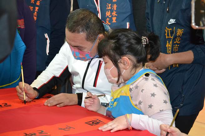 新北市土城清水市民活動中心今日啟用，新北市長侯友宜到中心內與小朋友作畫春聯，並在「平安祥虎」春聯題名，場面熱鬧。（蔡雯如攝）