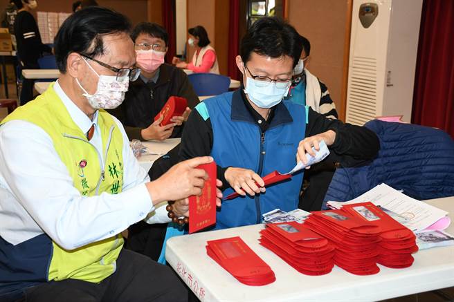 彰化市长林世贤协助分装要发给长者的春节敬老礼金。（吴敏菁摄）