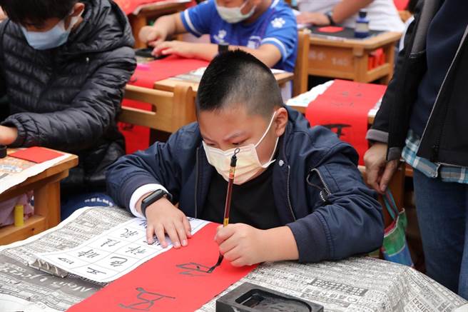 嘉义市育人国小小朋友认真写春联。（嘉义市政府提供）