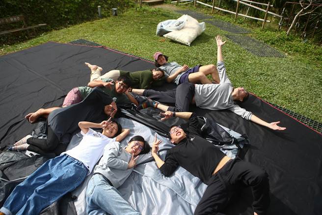 结束露营收完营帐后，躺在上面享受温暖的冬阳。（邓博仁摄）