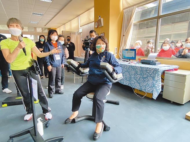 嘉義市長黃敏惠體驗精忠新城社區健身俱樂部的器材，民眾圍觀鼓掌。（廖素慧攝）