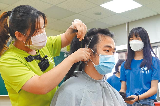 有感癌友化疗受落髮之苦，台东育仁高中学生响应捐髮活动，活动由导师张家维（中）率先剪去长髮。（蔡旻妤摄）