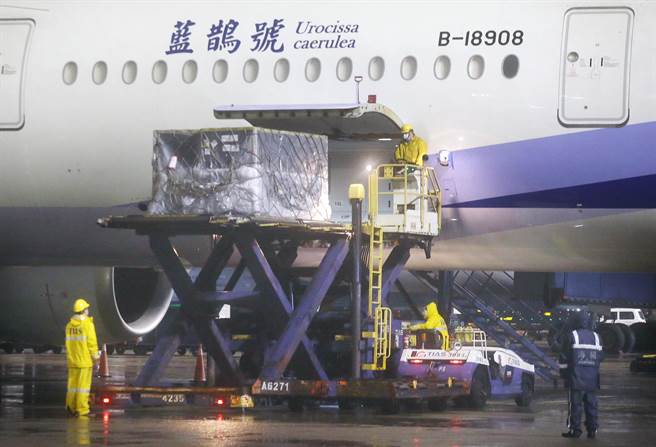 第16批BNT疫苗清晨运抵桃园机场，地勤人员卸下装载疫苗的冷冻货柜。（范扬光摄）
