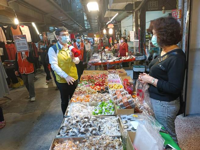 高市府经发局副局长高镇远21日率队赴凤山第一市场，手持大声公逐摊宣导防疫措施。（经发局提供）