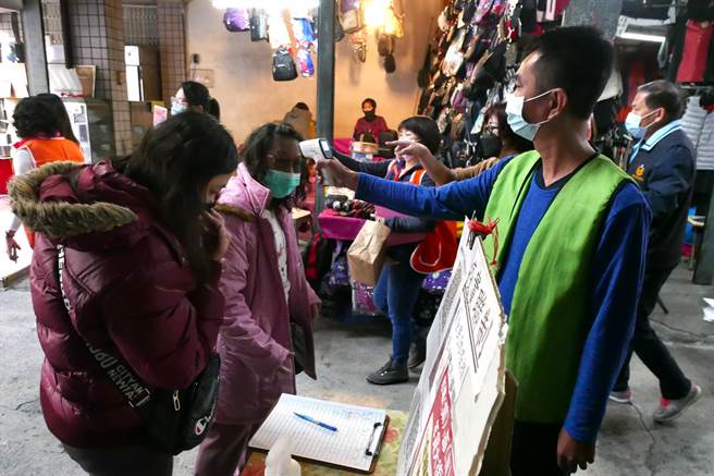市府人员于凤山第二市场出入口协助民眾落实实联制、量额温。（经发局提供）