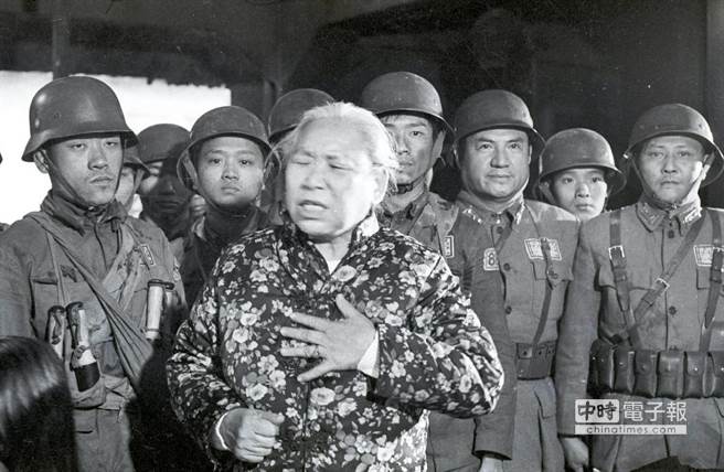 1975年中影拍摄「八百壮士」影片时，抗战期间在上海向四行仓库孤军献旗的女童军杨惠敏忆述当时的情形，饰演国军的演员细心听讲。（邱维国摄）