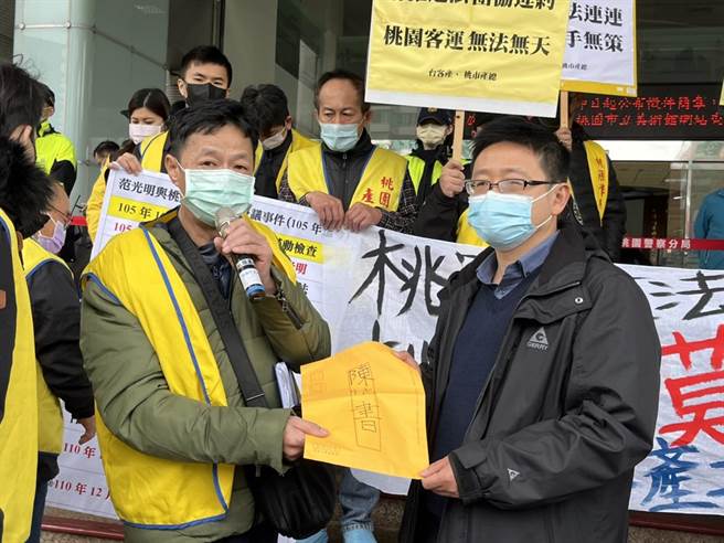范光明（图左）将陈情书交给劳动局劳资关系科长张哲航（图右）。（陈梦茹摄）