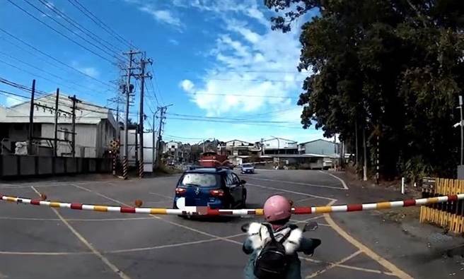 有两部自小客车跨越平交道遮断杆停在槽化线上。（吕姓民眾提供／张亦惠嘉县传真）