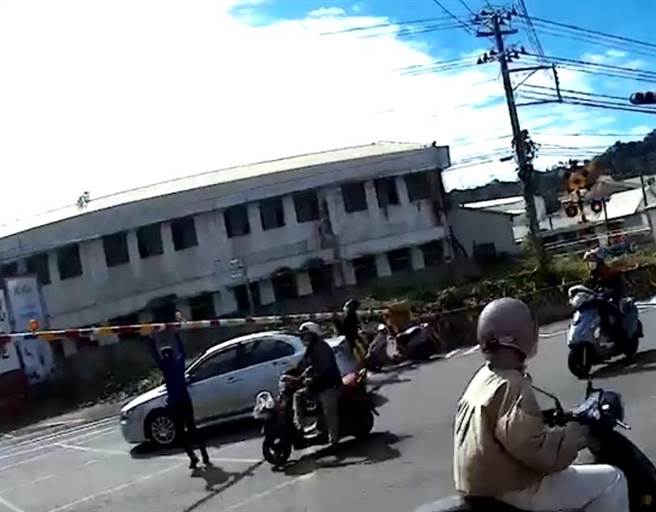 副驾驶座乘客及摩托车骑士下车帮忙抬起遮断杆。（吕姓民眾提供／张亦惠嘉县传真）