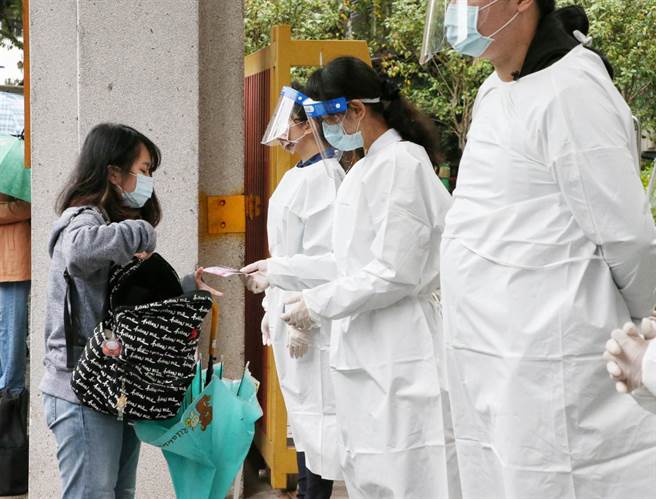 111年大学学测21日登场，考科为数学A、自然，因应新冠肺炎疫情影响，大考中心表示，考生应考须配合量体温、戴口罩，经复检后仍有发烧者，将安排防疫试场应试，在北市成功高中考场考生配合出示相关文件。（赵双杰摄）