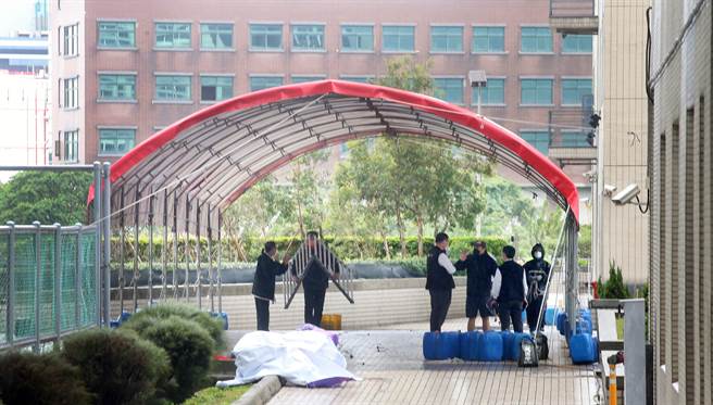 亚旭电脑惊爆新冠肺炎群聚感染，22日已累计70人确诊，该公司其余300多名移工全数送往集中检疫所隔离，一群工作人员在园区内搭设临时採检站，准备为港区内1万多名员工筛检。（范扬光摄）