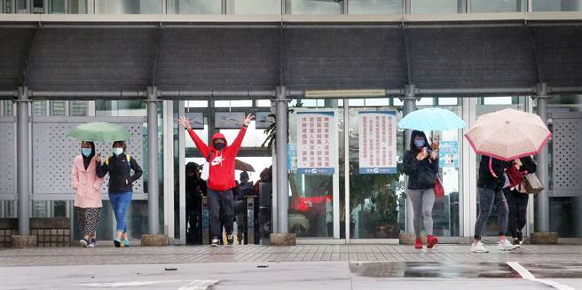 亚旭电脑惊爆新冠肺炎群聚感染，22日已累计70人确诊，该公司其余300多名移工全数送往集中检疫所隔离，一群其他公司的移工下班后走出园区大门。（范扬光摄）