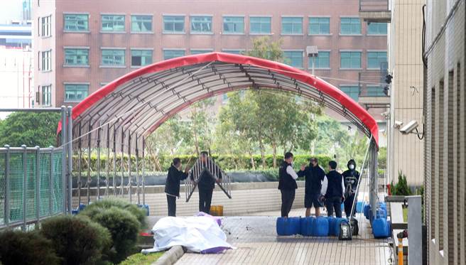 位于远雄自由贸易港区的亚旭电脑惊爆新冠肺炎群聚感染，22日已累计70人确诊，该公司其余300多名移工全数送往集中检疫所隔离，一群工作人员在园区内搭设临时採检站，准备为港区内1万多名员工筛检。（范扬光摄）