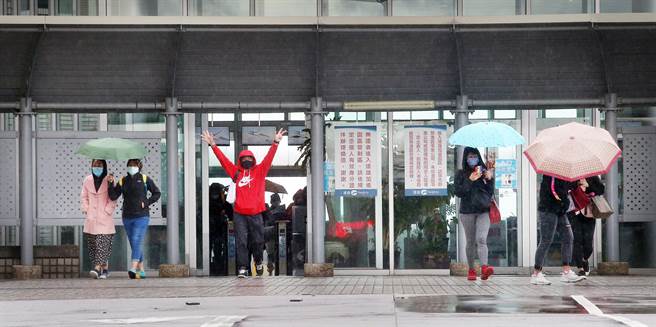 位于远雄自由贸易港区的亚旭电脑惊爆新冠肺炎群聚感染，22日已累计70人确诊，该公司其余300多名移工全数送往集中检疫所隔离，一群其他公司的移工下班后走出园区大门。（范扬光摄）