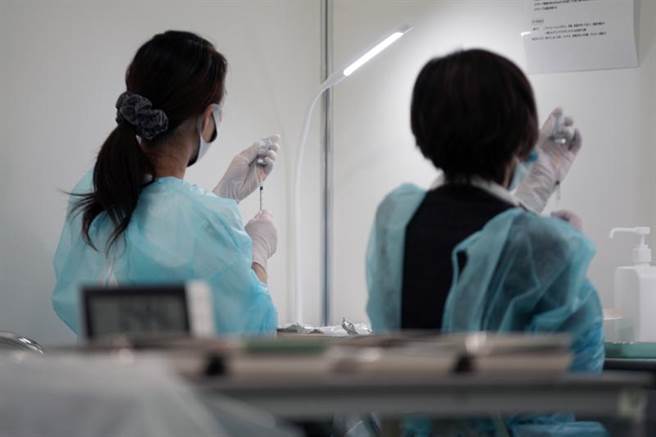 日本全境COVID-19疫情延燒，單日新增首逾5萬例，也是連5天創歷史新高。圖為準備疫苗追加劑的日本醫護人員。（圖／美聯社）