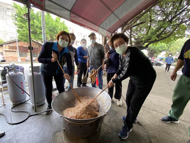 台中市南區國光社區發展協會，23日舉辦「捐購愛心年糕」活動，國光社區發展協會理事長、里長陳雅惠，國光社區發展協會常務理事邱素貞等人都捲起衣袖，加入志工的行列。（馮惠宜攝）