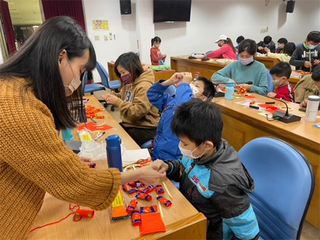 在折纸艺术家吕爰廷老师的指导下，新住民朋友利用春联纸折出喜气洋洋的财神爷，以及应景又环保的纸鞭炮挂饰。（移民署提供）