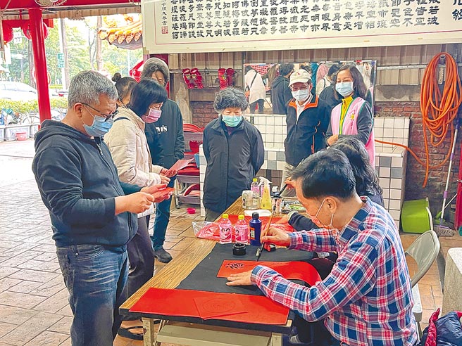 台中东区东兴里办公处与台中市水噹噹关怀协会、市议员邱素贞服务处、台湾省书画教育协会，22日上午在东区立德东街、仁和路口的南门福神祠前广场，举办「写春联、送春联」活动。（冯惠宜摄）
