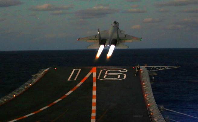 解放軍航母「遼寧」艦編隊2021年底進行遠海實戰化訓練，殲-15艦載戰機夜間起降的畫面。（新華社）