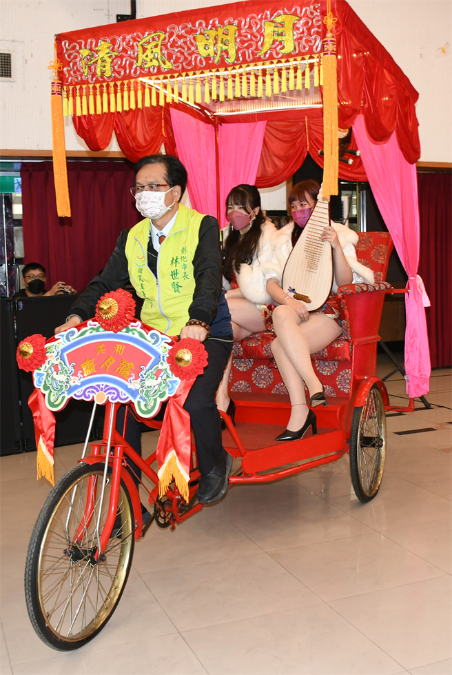 彰化市長林世賢（左）踩著黃包車三輪車為彰化市2月12日登場的古城踩街趣活動宣傳暖身，後座坐著兩位國樂美人，十分復古。（謝瓊雲攝）
