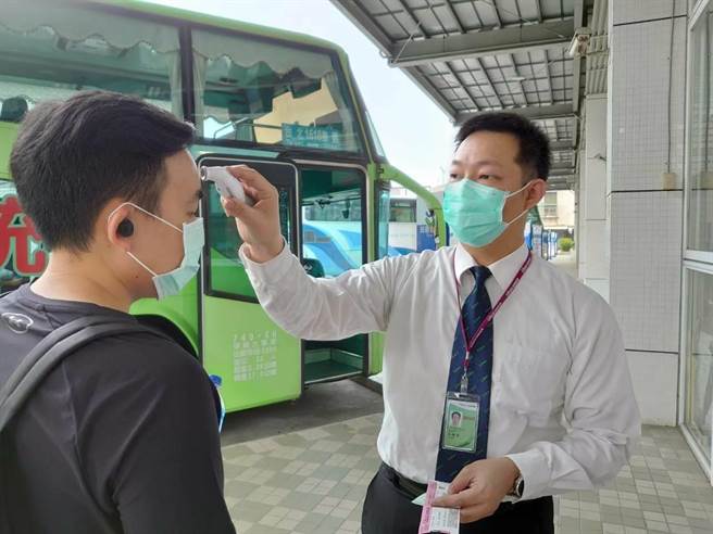 嘉義轉運中心工作人員為乘客量測體溫。（謝連仲提供）