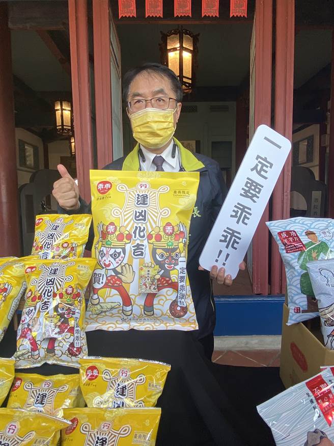 黄伟哲于国定古蹟赤崁楼宣传「2022台南行春」活动，拿着「一定要乖乖」标语，希望疫情跟病毒都乖乖。曹婷婷摄）