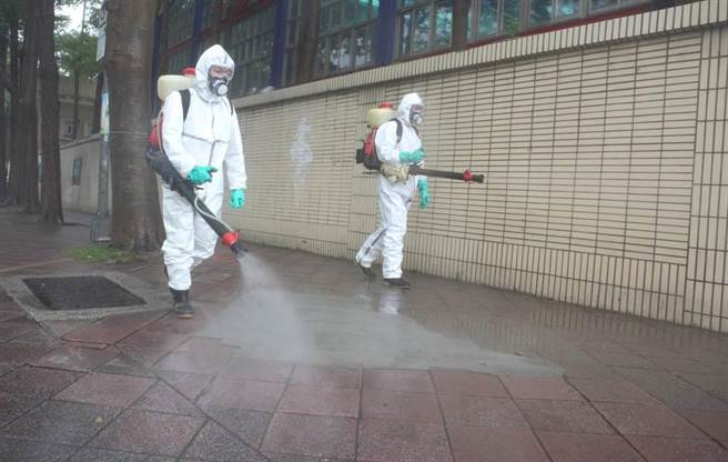 新北市今新增1例，新北市衛生局表示，個案為家住板橋50多歲男子，是北市房仲的客戶。圖為環保局人員也在校園內外進行清消。（資料照，張鎧乙攝）