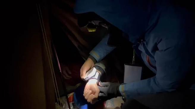 梁姓山友在雪山圈谷不慎坠落，雪霸国家公园管理处志工服务员吴峻德与热心山友紧急出动赴雪山圈谷救援，替梁某量测身体状况无碍。（吴峻德提供／谢明俊苗栗传真）