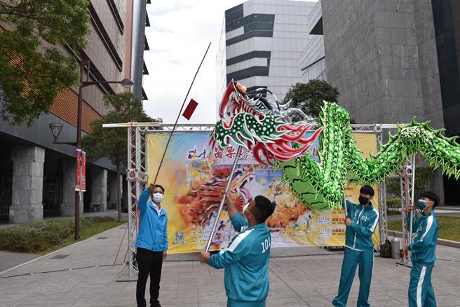 苗栗市长邱镇军示范「龙嘴叼红包」，由龙头咬下挂在竹竿上的红包。（谢明俊摄）