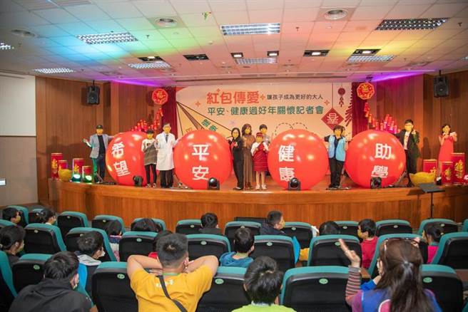（中国附医院长周德阳（舞台上左3）等人，26日特与台湾世界展望会合作，藉由「红包传爱~平安、健康过好年」活动。图／中国附医提供）
