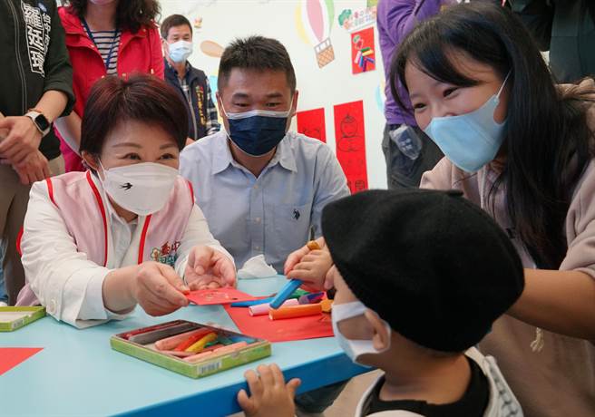 台中市長盧秀燕27日特別到大里親子館視察館內防疫措施，並觀摩示範玩具的消毒流程，也發給家長小孩小紅包。（黃國峰攝）