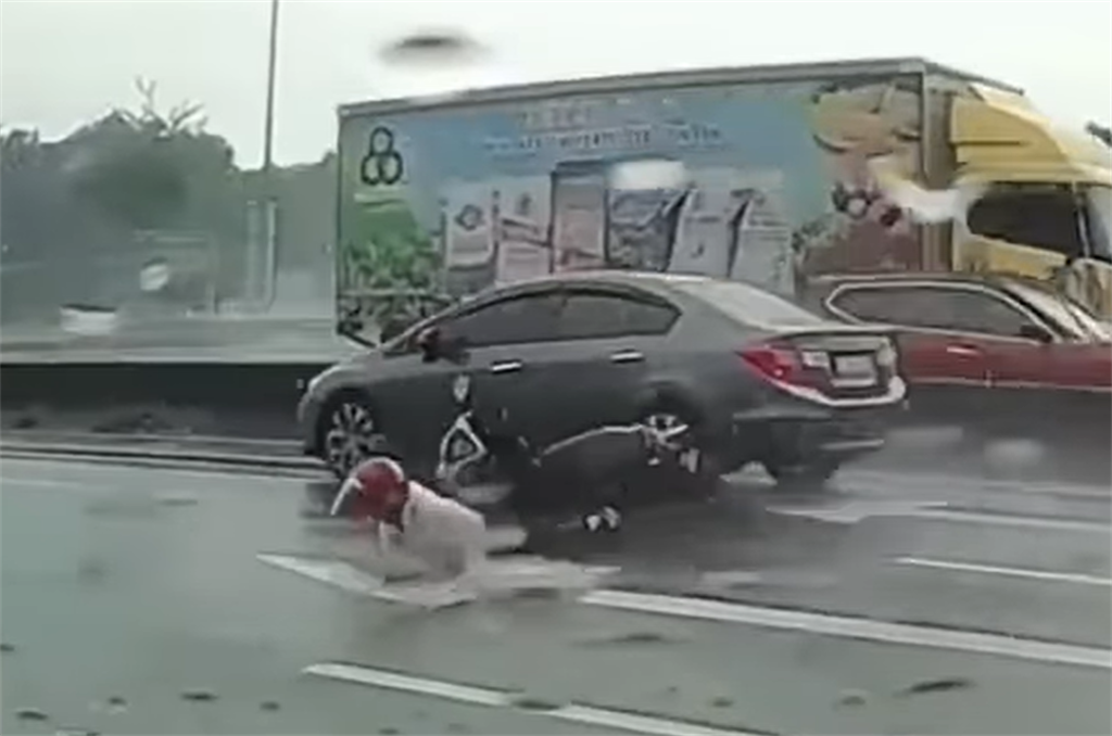 一名騎士雨中在內側車道自摔，但他卻使出瞬間脫逃術，迅速爬起後，2秒內連續躲過後方高速經過的自小客，及大貨車逃到路旁逃命，險遭到輾過。(翻攝臉書社團「八卦村 - 行車紀錄器影片上傳中心」）