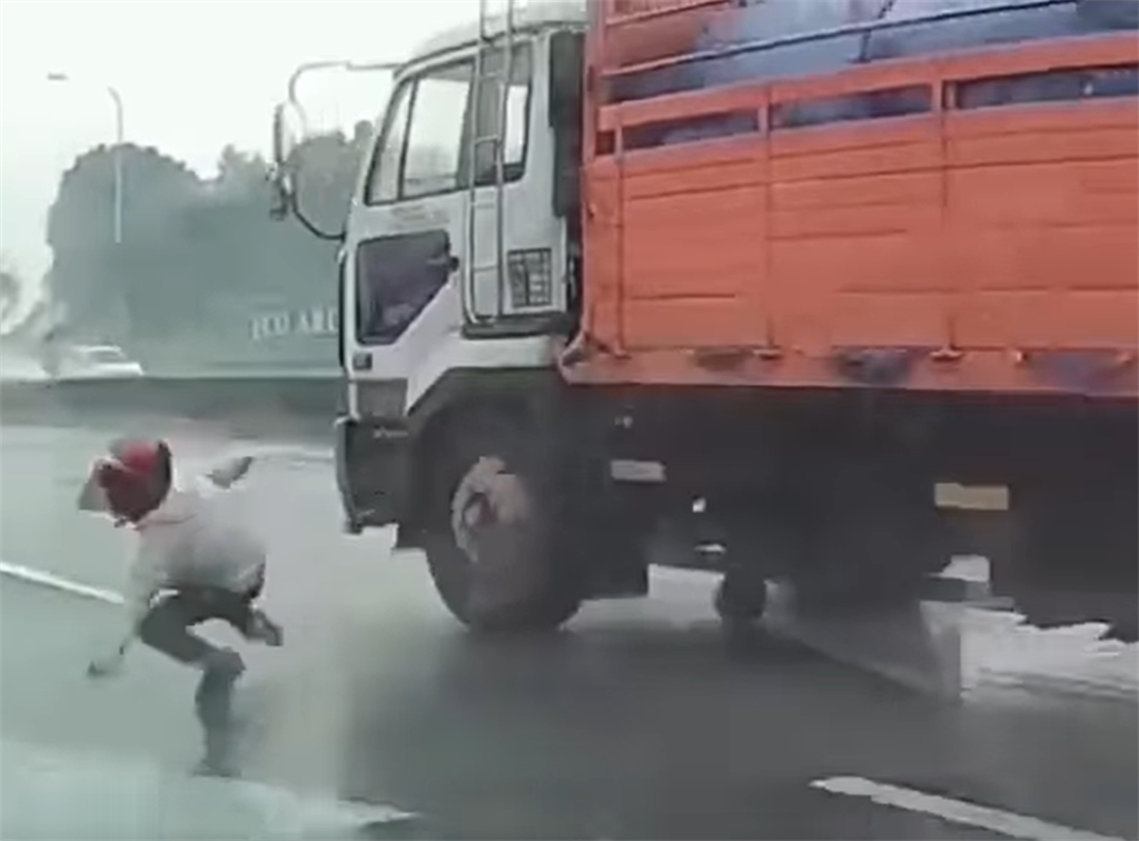 一名騎士雨中在內側車道自摔，但他卻使出瞬間脫逃術，迅速爬起後，2秒內連續躲過後方高速經過的自小客，及大貨車逃到路旁逃命，險遭到輾過。(翻攝臉書社團「八卦村 - 行車紀錄器影片上傳中心」）