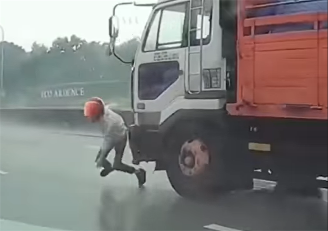 一名騎士雨中在內側車道自摔，但他卻使出瞬間脫逃術，迅速爬起後，2秒內連續躲過後方高速經過的自小客，及大貨車逃到路旁逃命，險遭到輾過。(翻攝臉書社團「八卦村 - 行車紀錄器影片上傳中心」）