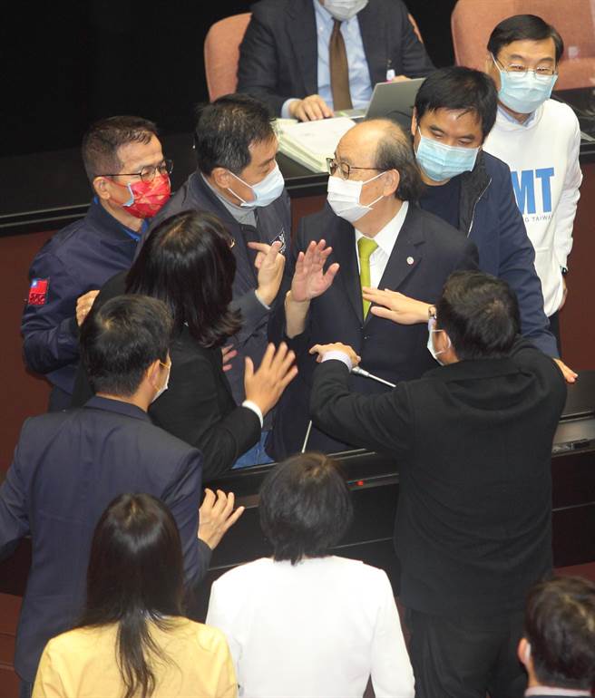 立法院臨時會最後一天繼續審查中央政府總預算案，表決前民進黨團總召柯建銘批評國民黨EQ和IQ退化，國民黨立委蜂擁包圍發言台表達抗議。（張鎧乙攝）