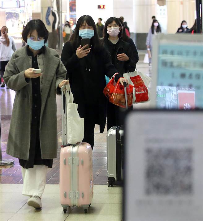 春节9天连假29日开始，28日最后一个年前工作日，在新北市板桥车站出现搭车返乡人潮，大家拖着行李准备回家团圆过新年，在进入月台前也不忘做好实名制防疫。（赵双杰摄） 