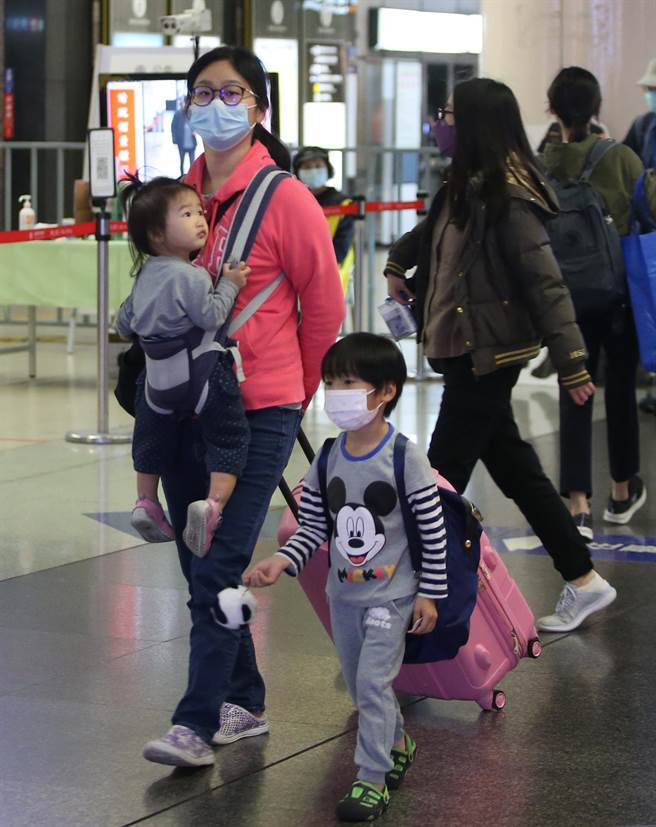 在新北市板桥车站出现搭车返乡人潮，家长带着小孩拖着行李准备回家团圆过新年。（赵双杰摄） 