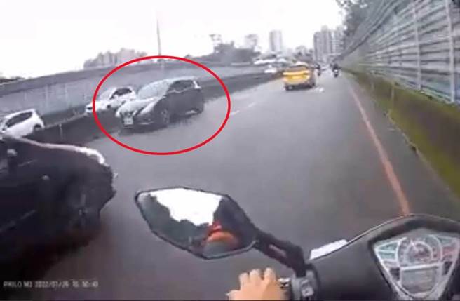 一輛黑色小轎車逆向行駛內側車道，計程車與轎車接連驚險閃過。（翻攝爆料公社影片）